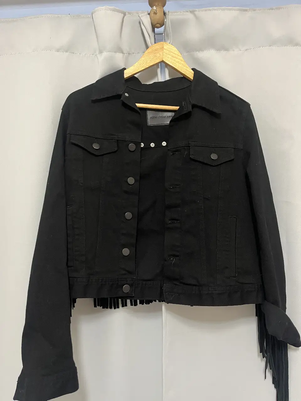 Campera de jean negra con flecos en la espalda y mangas. Estilo rocker y detalles de tachas. Jazmin Chebar Jeans.