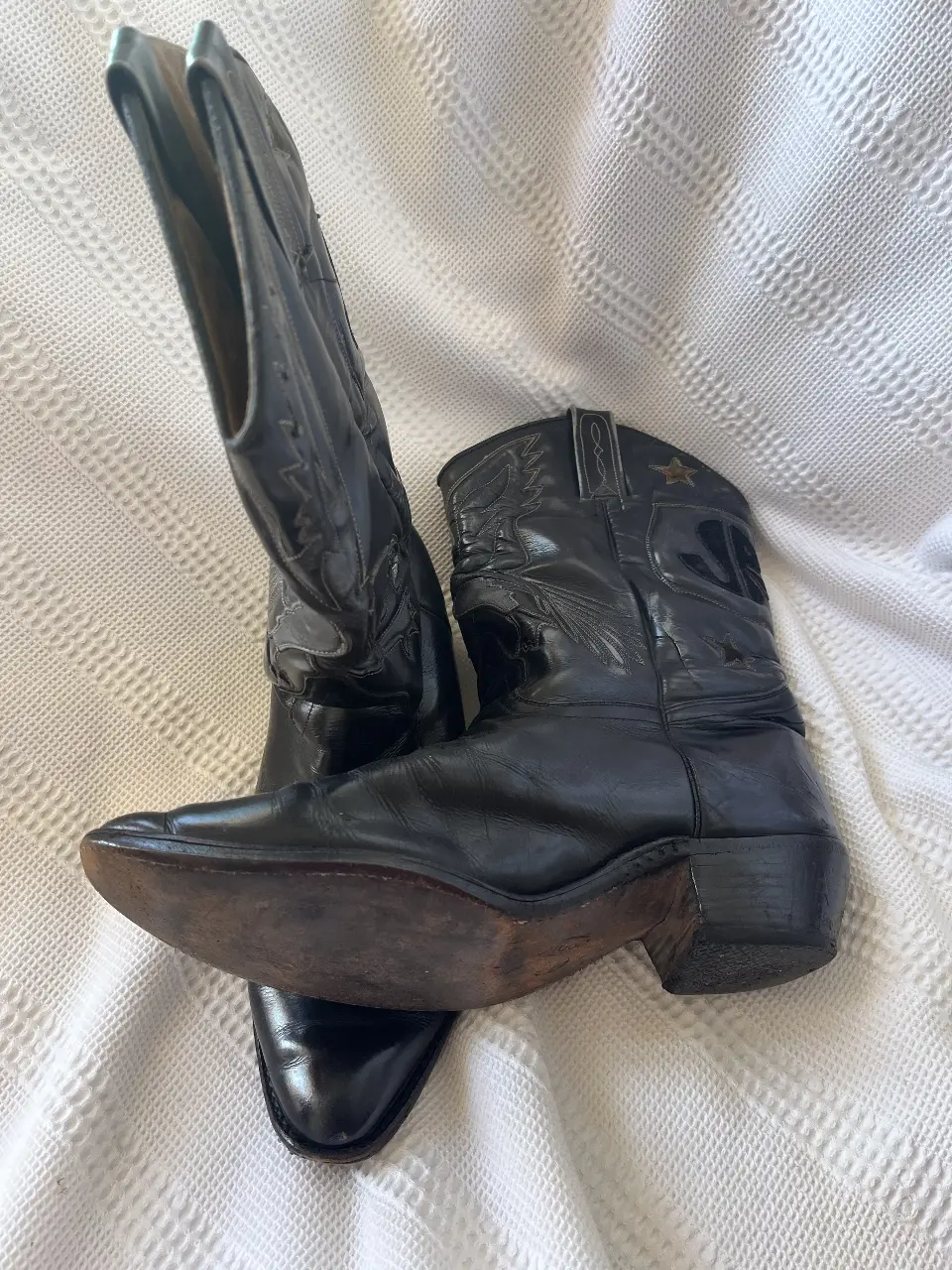 Botas de cuero negro con detalles de estrellas y letras. Estilo cowboy, ideales para un look audaz y con personalidad.