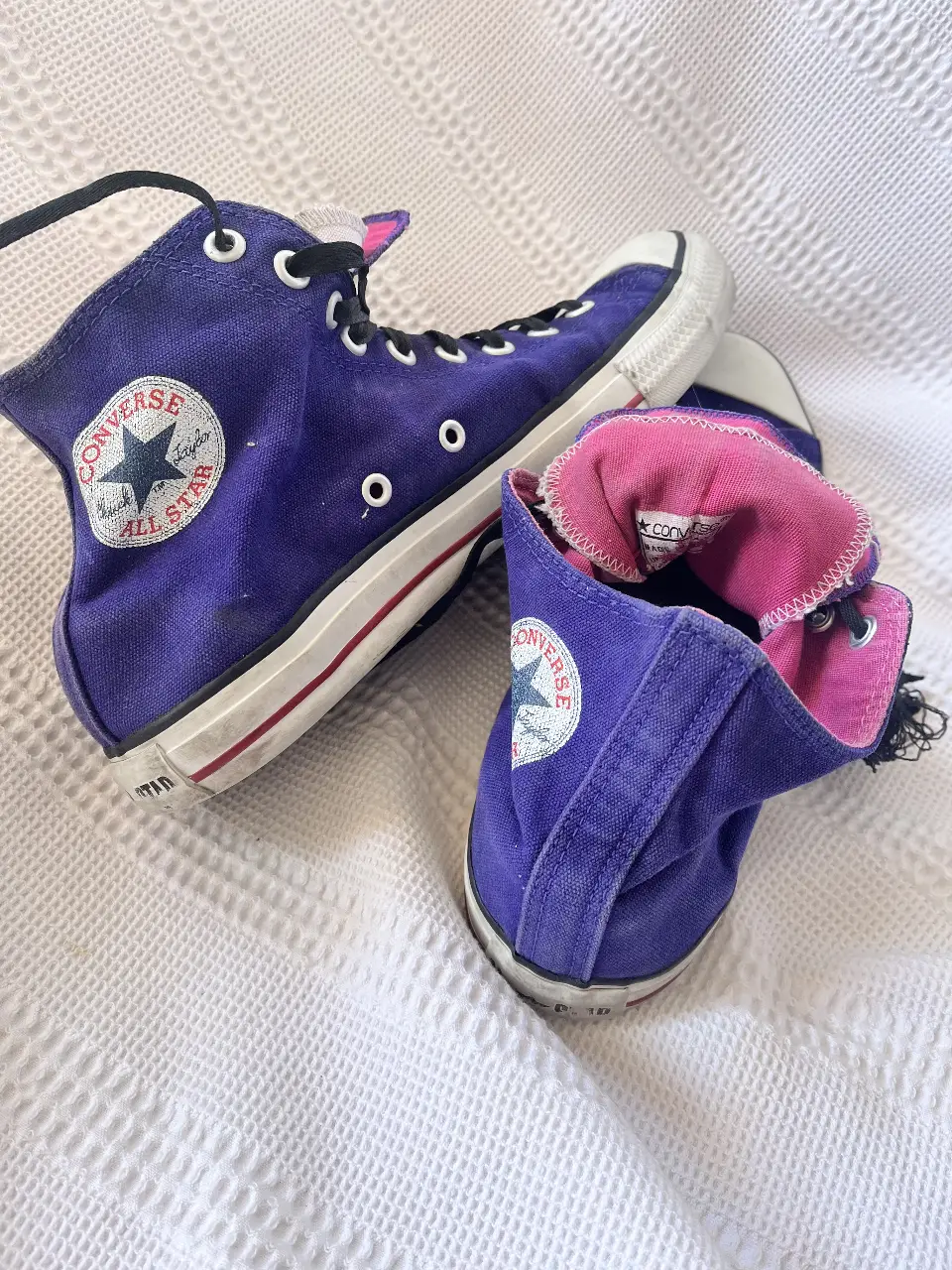 Zapatillas Converse All Star de caña alta en color violeta. Diseño clásico con puntera blanca y suela de goma. Ideales para un look casual y urbano.