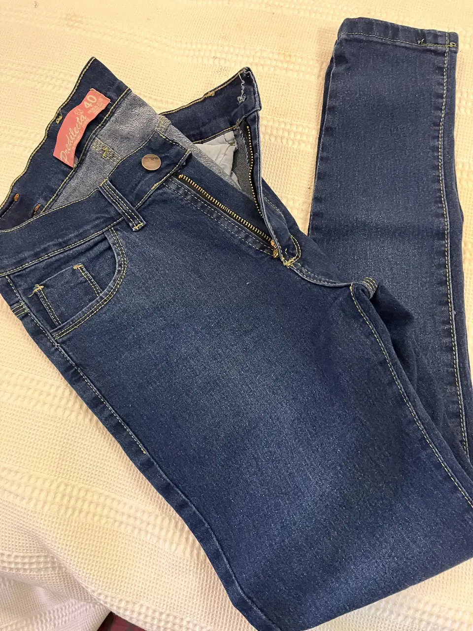 Jeans de mujer, tiro medio, color azul oscuro. Talle 40. Diseño chupin de cinco bolsillos, con cierre y botón.