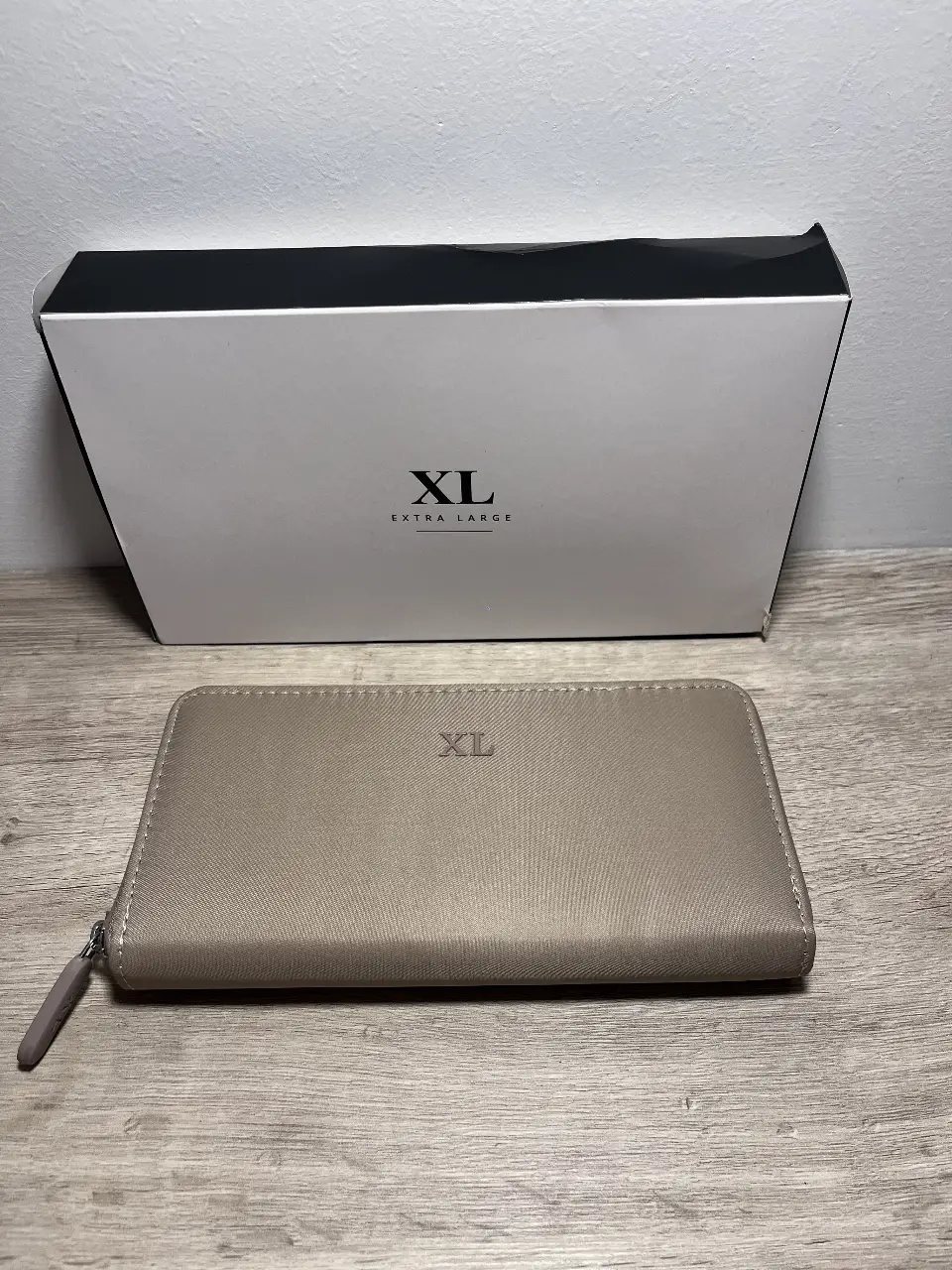 Billetera XL Extra Large de color crudo, con cierre y detalles de la marca. Ideal para llevar tus pertenencias con estilo y organización.