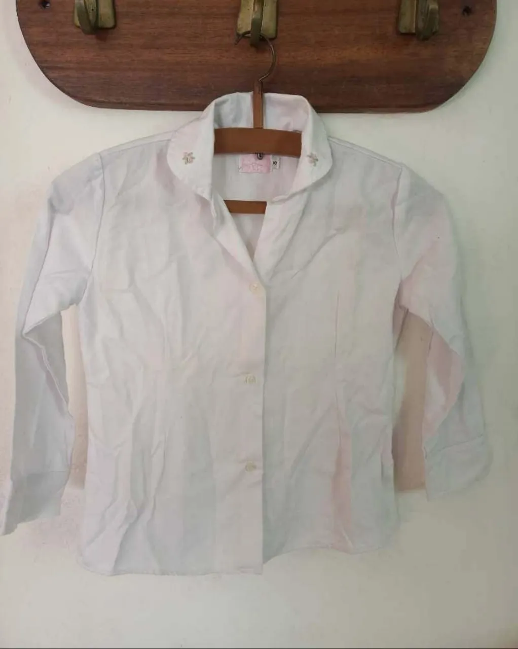 Camisa blanca de manga larga con detalles bordados en el cuello. Perfecta para un look casual o para la escuela.
