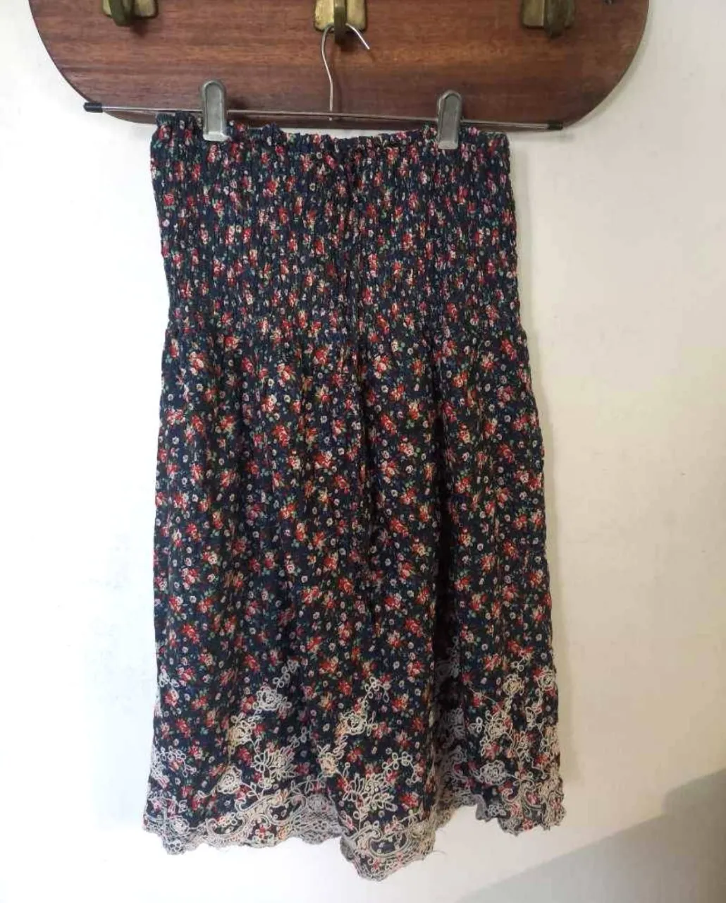 Pollera larga con estampado floral en tonos oscuros y detalle de encaje en el borde. Tiene forro de nylon y elástico en la cintura por lo tanto cede mucho. Ideal para un look bohemio y femenino. 