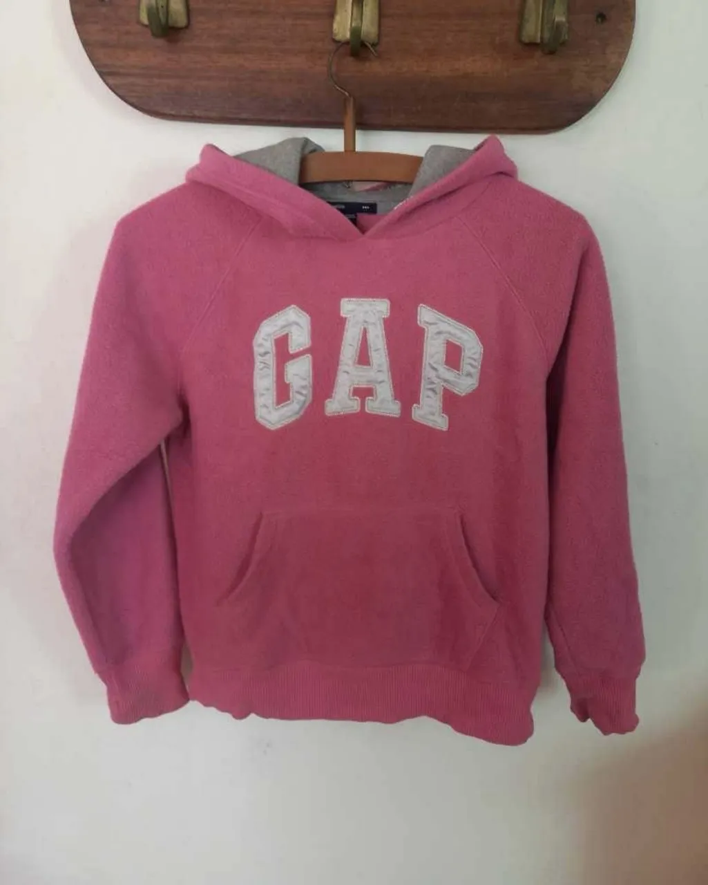 Buzo de GapKids con un bolsillo delantero y el iconico GAP logo en el pecho. Perfecto para usar todo los días, este cómodo buzo es ideal para días fríos. 