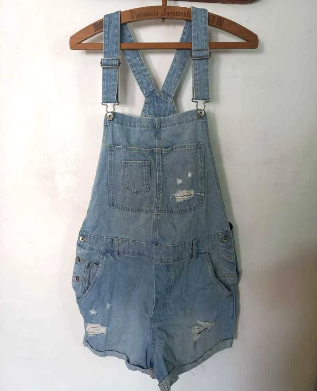 Overol corto de jean azul claro con detalles rotos. Tiene una pequeña mancha poco visible en la parte baja del short. Ideal para un look casual y canchero. Perfecto para el verano.