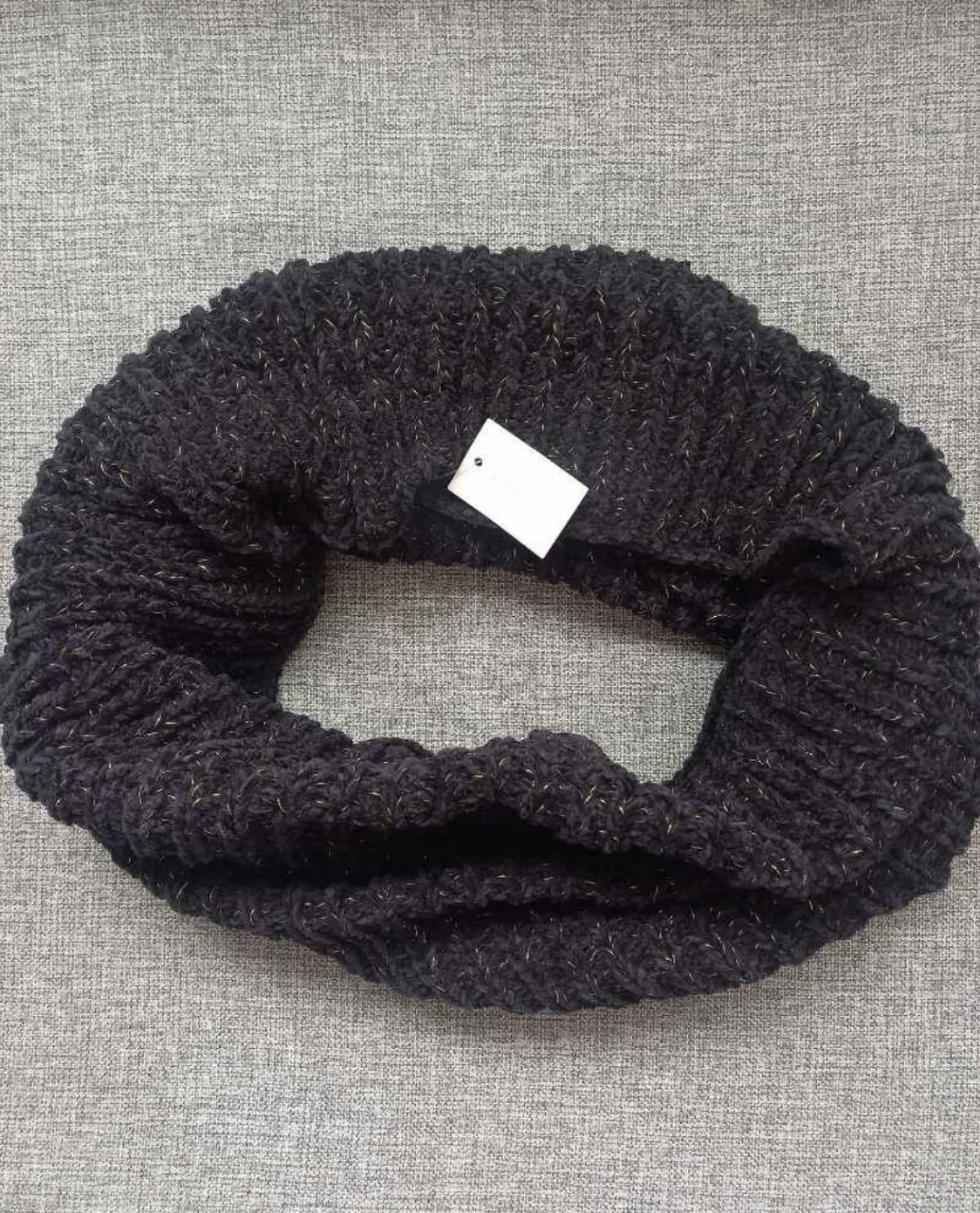 Bufanda infinita tejida en color negro con hilos dorados que le dan un toque brillante. Es súper suave y cálida, ideal para complementar tus outfits de invierno.