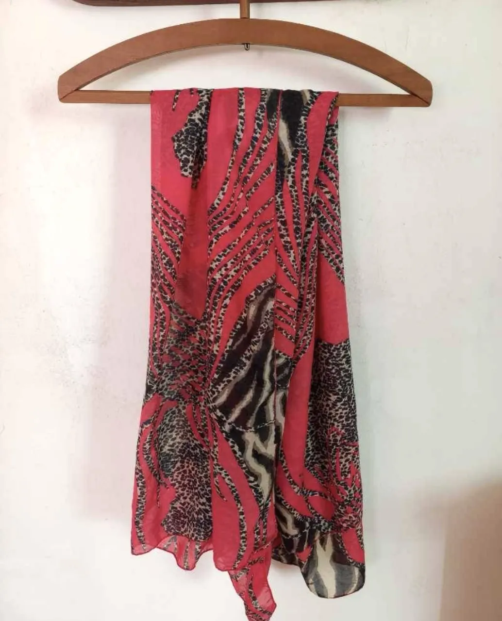 Pañuelo estampado animal print en tonos rojos y negros. Ideal para darle un toque de estilo a cualquier look.