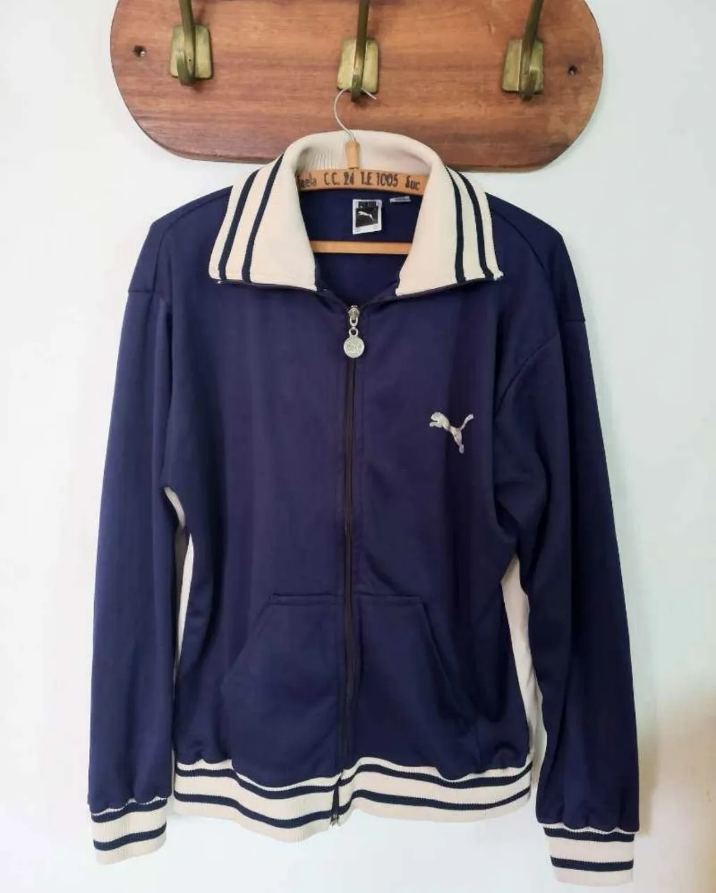 Buzo deportivo Puma vintage con cierre, azul marino con detalles blancos. Logo bordado en el pecho y detalles en cuello y puños. Talle L. Únicos detalles el logo un poco gastado y un pequeño agujero casi invisible.