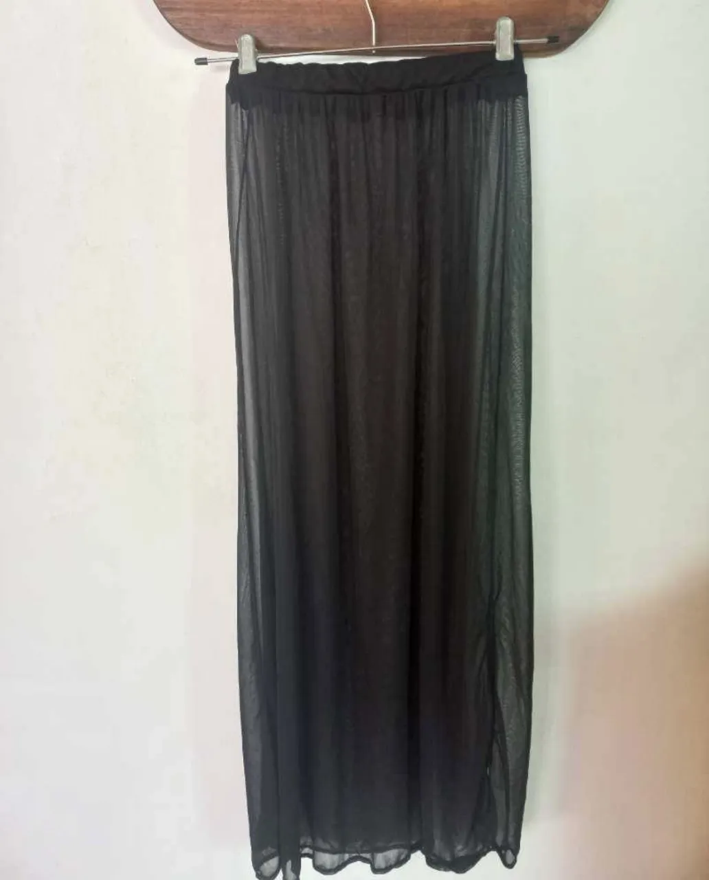 Pollera larga negra de tul, ideal para usar sobre trajes de baño o como parte de un look de festival. Transparente y con un diseño vaporoso.