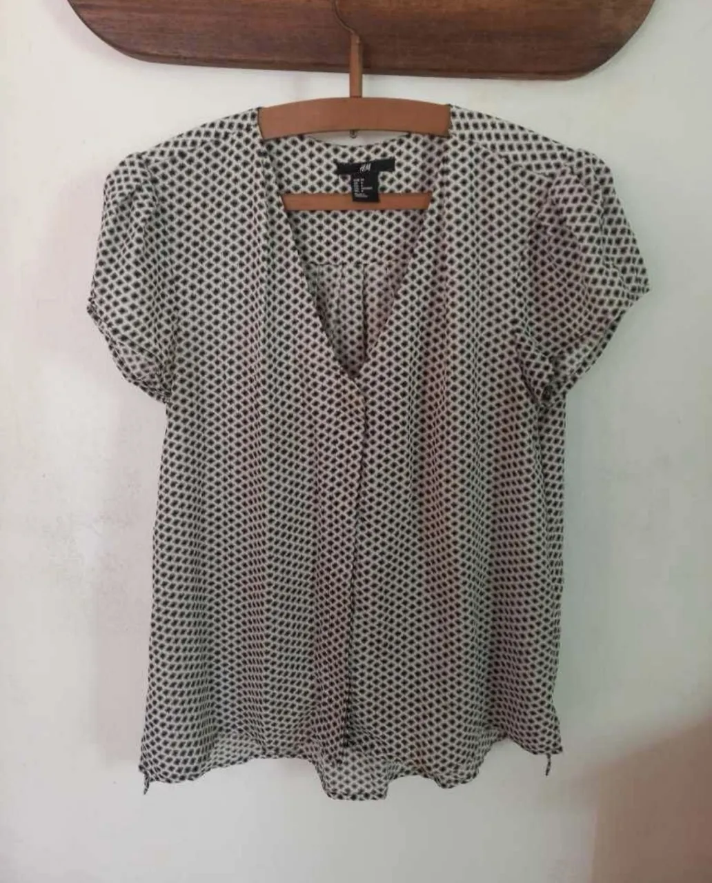 Blusa H&M estampada con cuello en V y mangas cortas. Diseño moderno y versátil, ideal para cualquier ocasión.