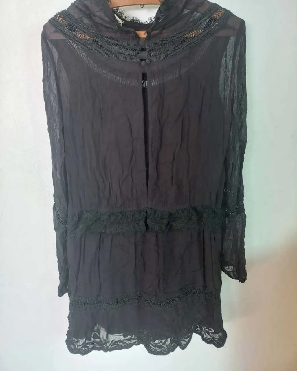 Vestido negro largo con detalles de encaje y volados. Manga larga y cuello alto con botones. Ideal para un look boho o romántico.