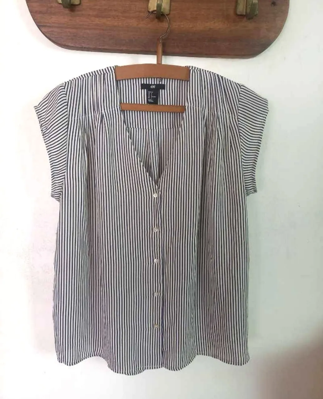 Blusa de mujer a rayas verticales, con botones y cuello en V. Ideal para un look casual y fresco.