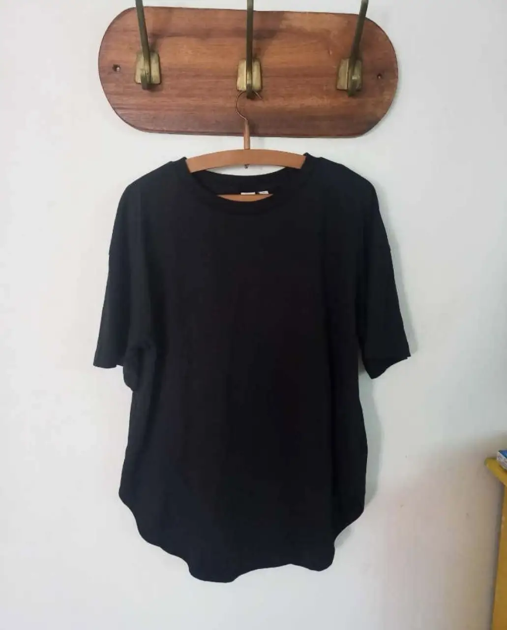 Remera negra de corte holgado, con mangas cortas y cuello redondo. Ideal para un look casual y cómodo.