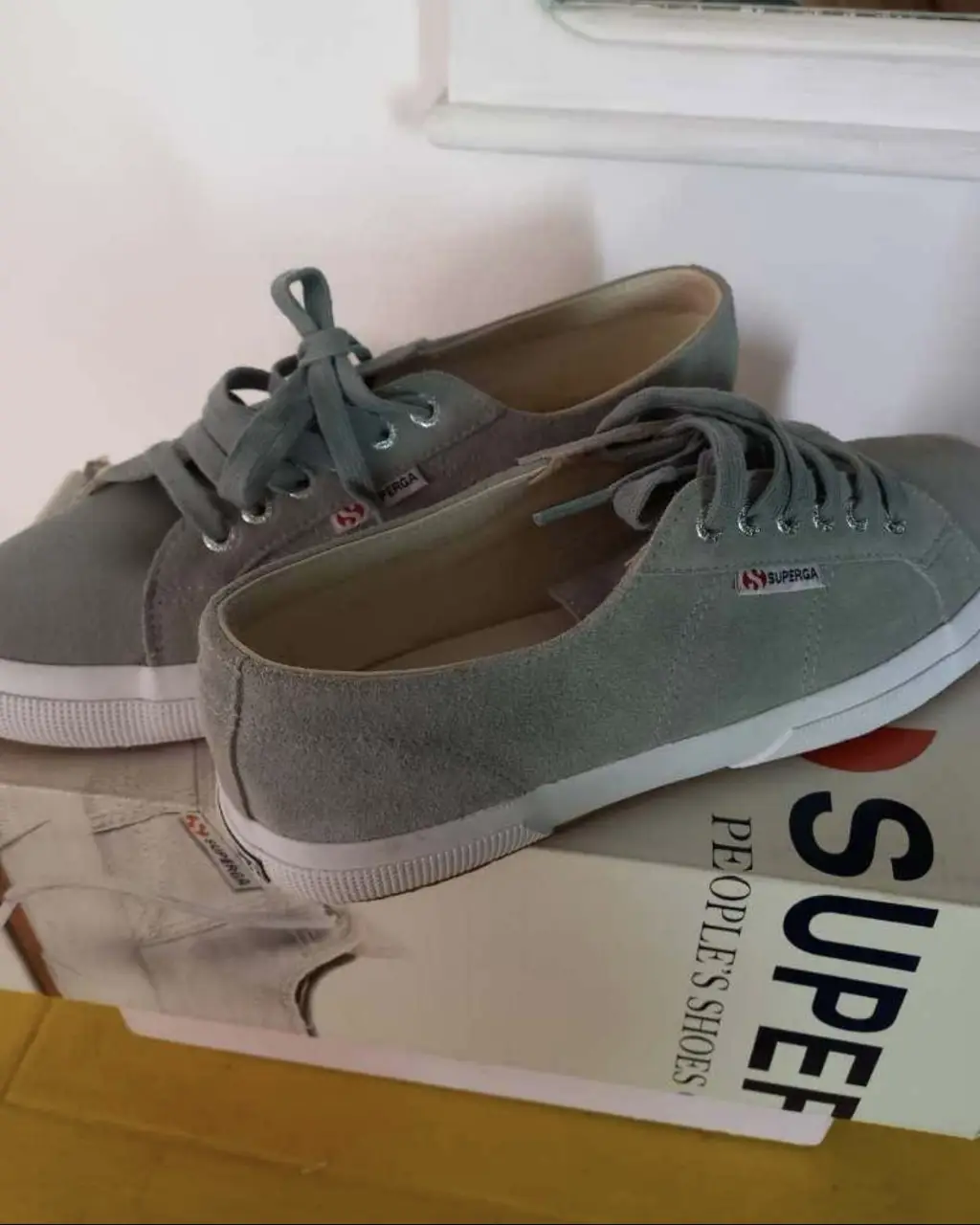 Zapatillas Superga de gamuza con suela blanca. Tienen cordones y el logo de la marca en el lateral y en la parte trasera. Ideales para un look casual y cómodo.
