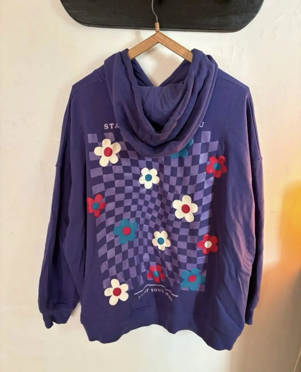 Buzo canguro violeta con estampado floral en la espalda y frase "Stay Focused On You". Talle XL. Ideal para un look casual y cómodo.