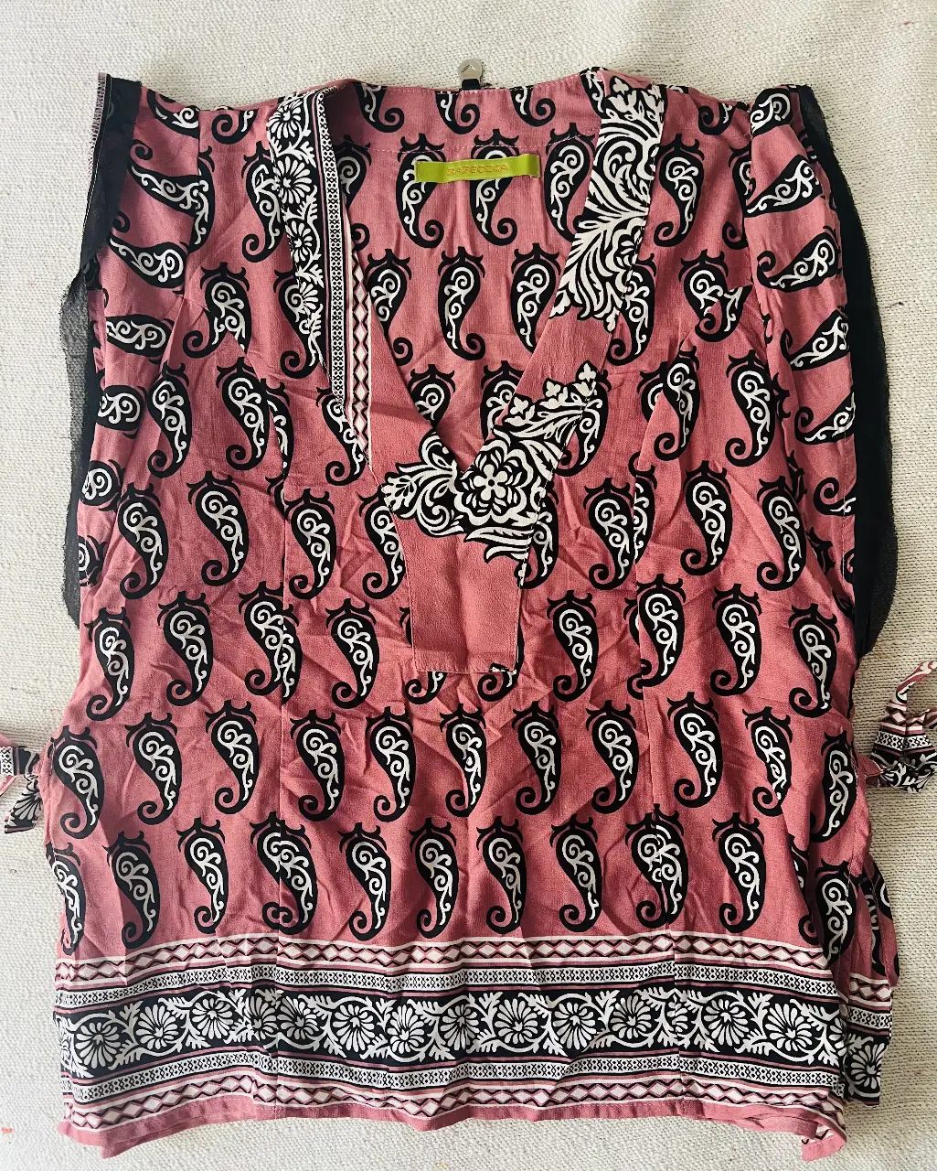 Blusa de mujer con estampado paisley en tonos rosa y blanco. Diseño con cuello en V y detalles de la marca. Ideal para un look casual y bohemio.