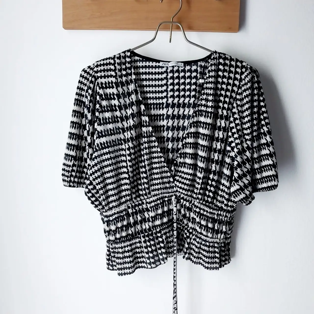 Blusa de mujer con estampado en blanco y negro. Diseño con escote en V y detalle fruncido en la cintura. Manga corta. Marca Zara.