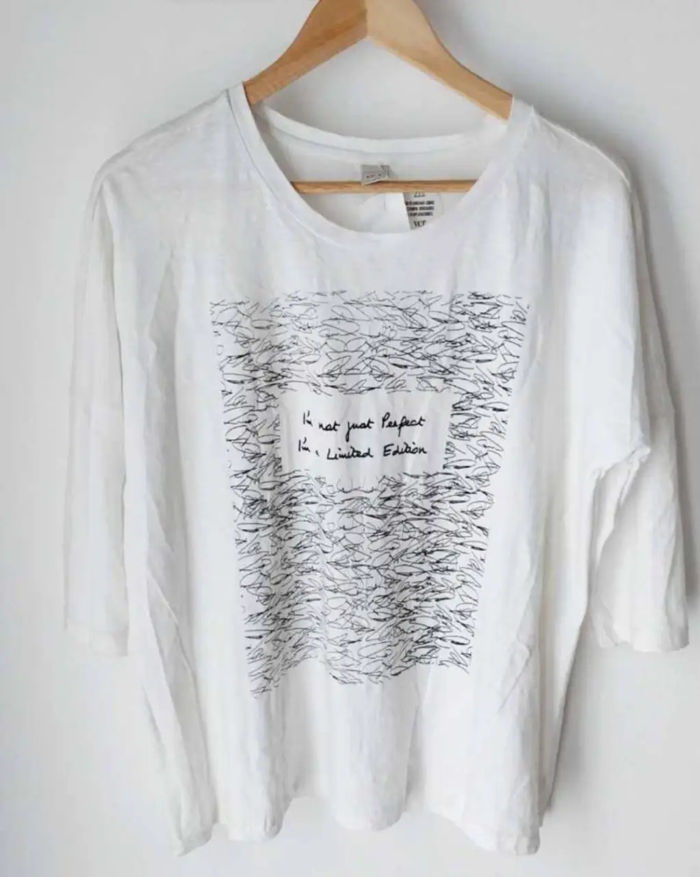 Remera blanca con mangas 3/4 y estampado en el frente. 100% algodón. Pecho 59 cm, Hombros 62 cm