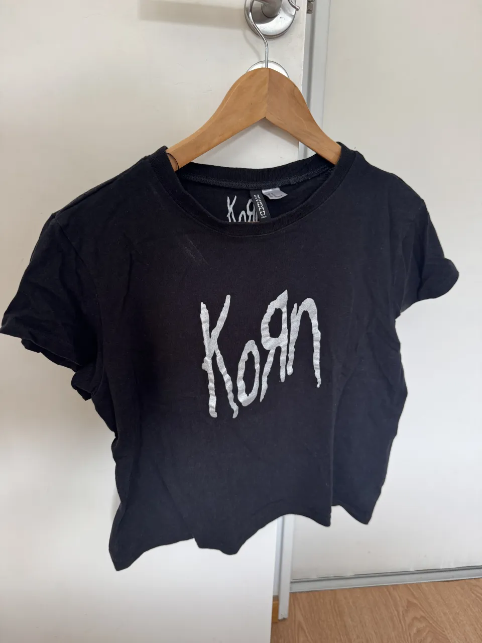 Remera negra crop con estampa de la banda Korn. Ideal para un look rocker o casual.