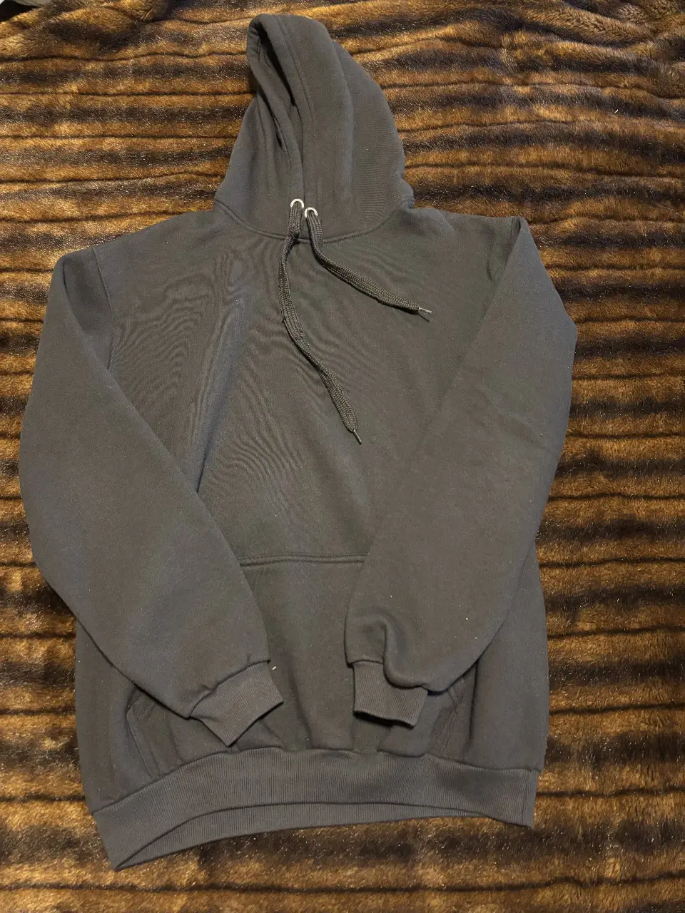 Buzo canguro negro, ideal para un look casual y cómodo. Perfecto para el día a día o para actividades deportivas.