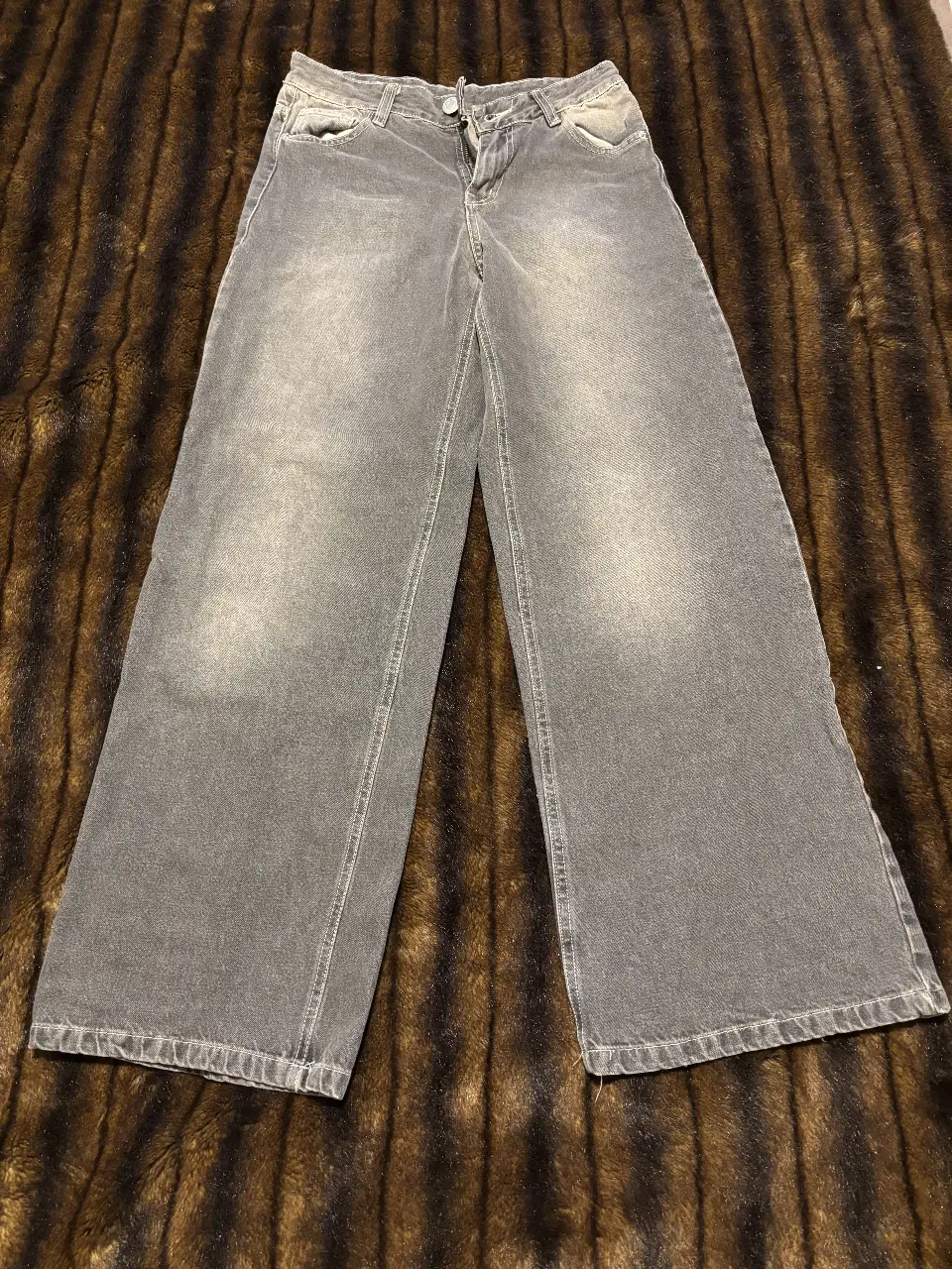 Jeans grises de corte ancho, tiro medio y talle 26. Ideal para un look casual y moderno.