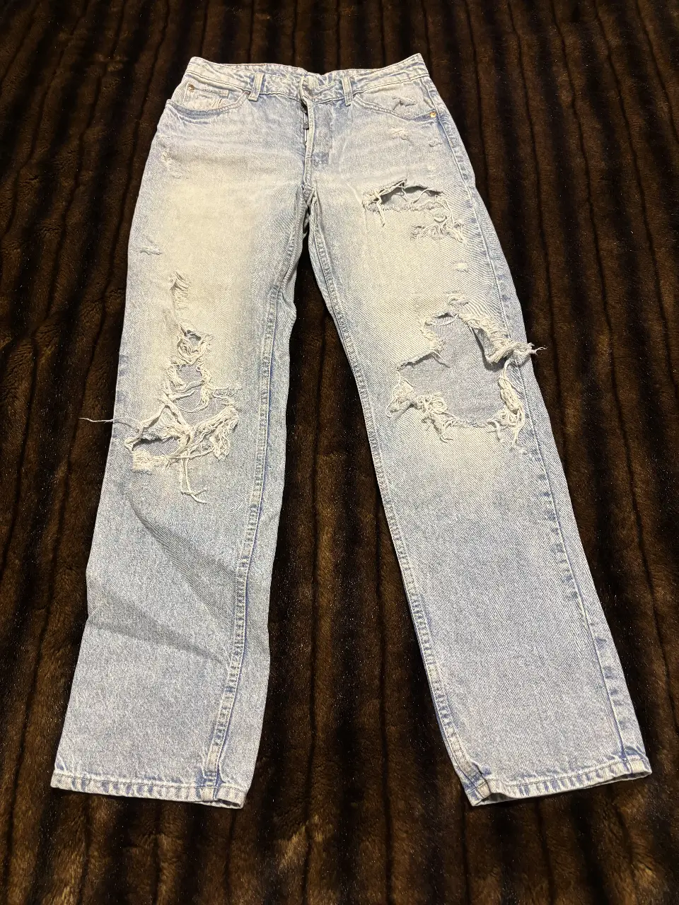 Jeans de mujer, tiro medio, con roturas y detalles desgastados. Estilo 90's boyfriend, ideal para un look casual y moderno.