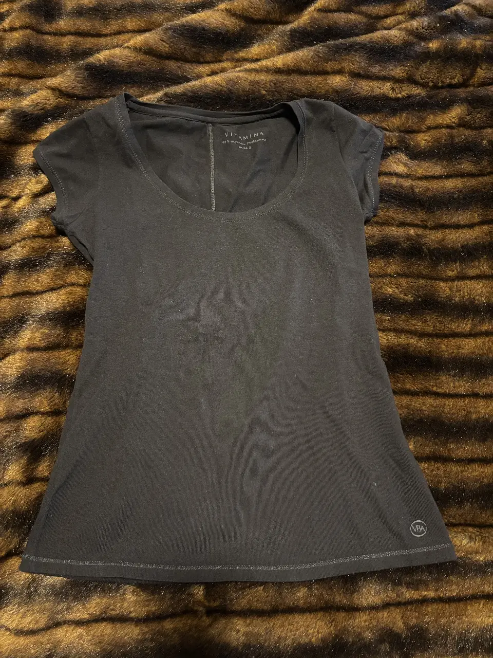 Remera negra de manga corta para mujer, con cuello redondo y detalle de costura en la espalda. Marca Vitamina, confeccionada en 93% algodón y 7% elastano. Talle 2.