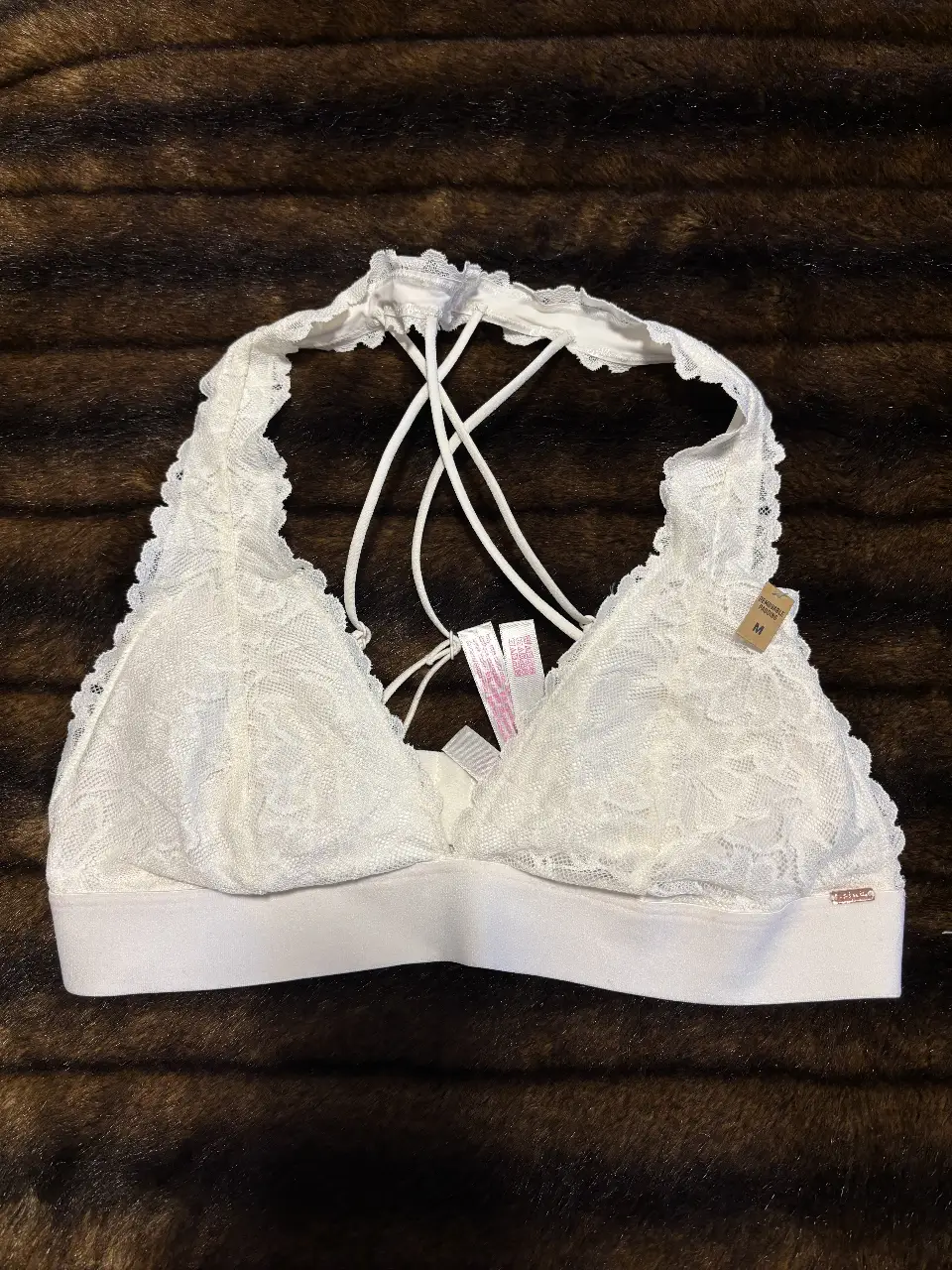 Corpiño Pink de encaje blanco con espalda cruzada y detalle de volados. Ideal para un look delicado y cómodo.