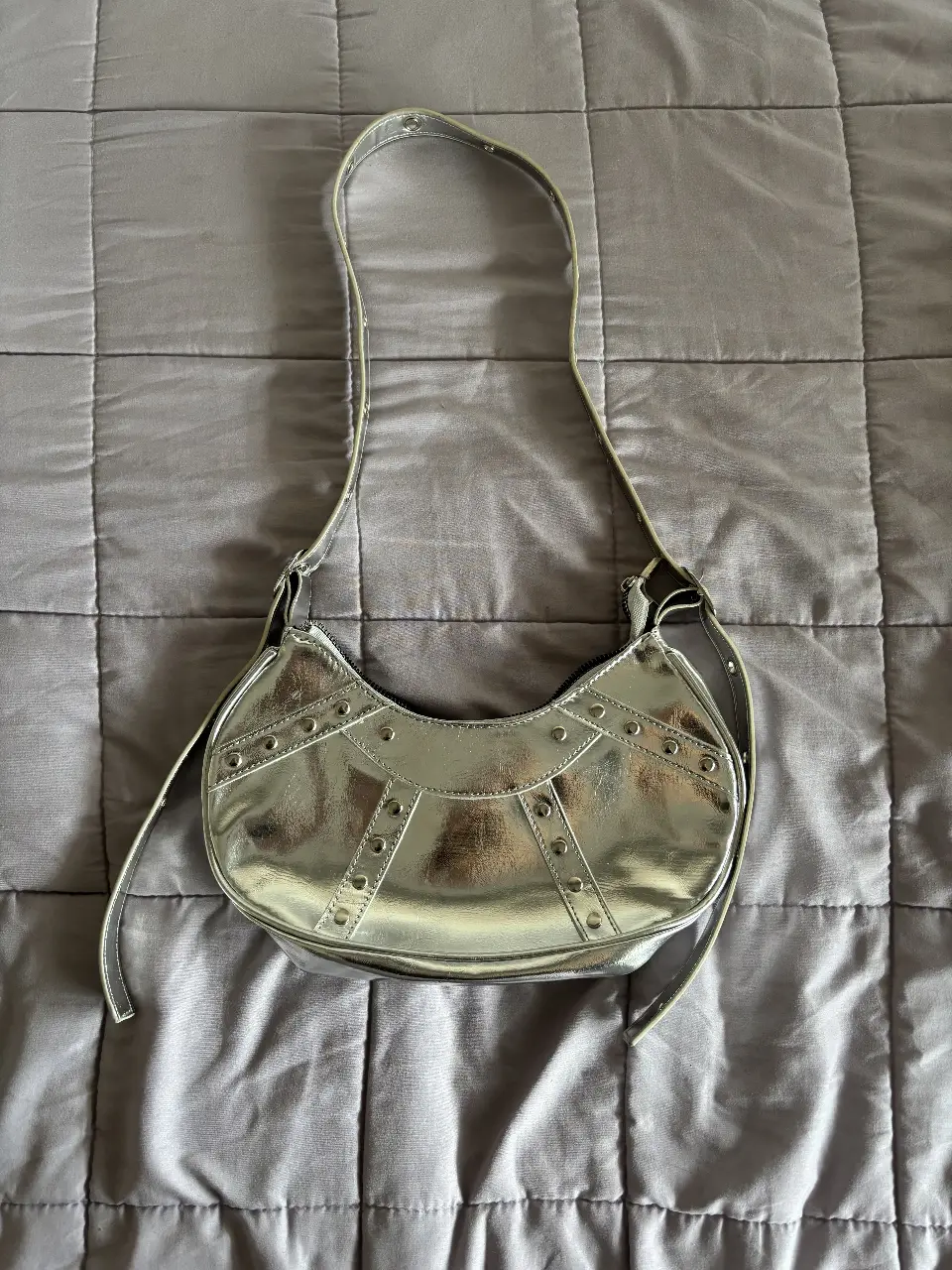 Cartera plateada con detalles de tachas, ideal para un look Y2K o para darle un toque moderno a cualquier outfit. Perfecta para salidas y eventos.