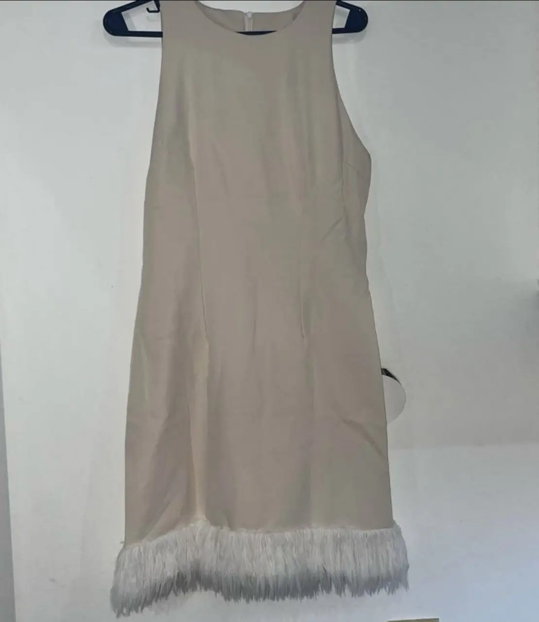 Vestido midi color crudo con detalle de flecos en el bajo. Ideal para eventos especiales o salidas.