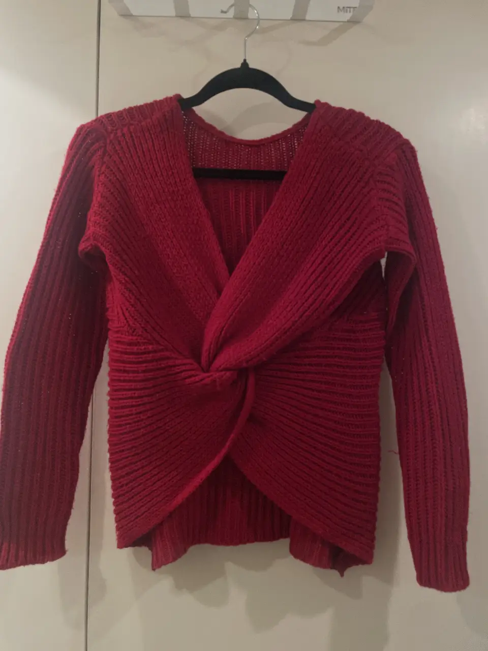Sweater rojo con diseño cruzado en el frente. Ideal para un look moderno y abrigado. Perfecto para combinar con jeans o pantalones de vestir.