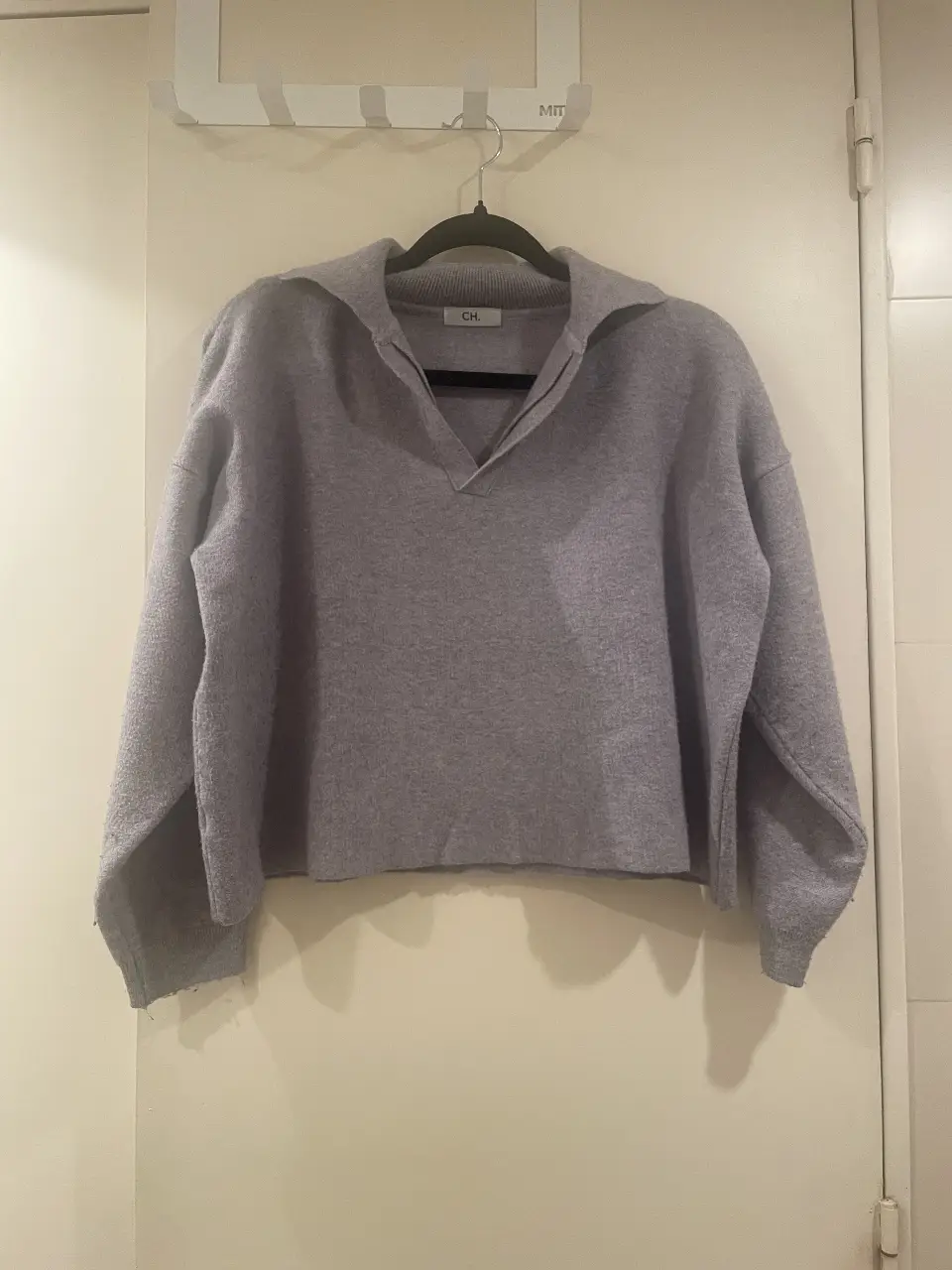 Sweater gris con cuello en V, ideal para un look casual y cómodo. Perfecto para el día a día.