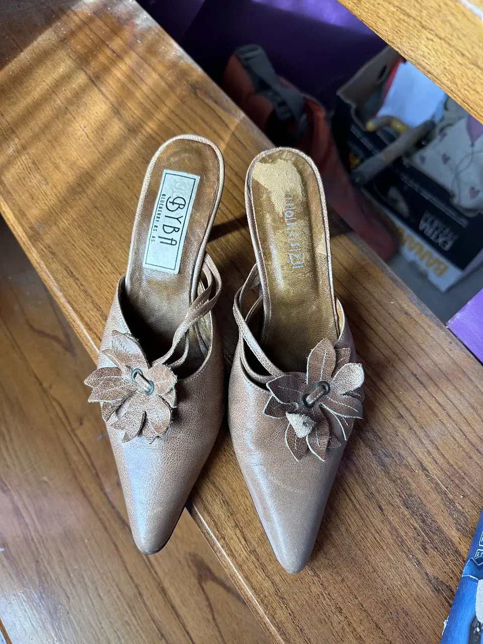 Lindos tacos de cuero color marrón con detalle de flor en la parte delantera. Ideales para una ocasión especial o para darle un toque elegante a tu look diario. Tienen un diseño vintage y femenino. Marca BYBA