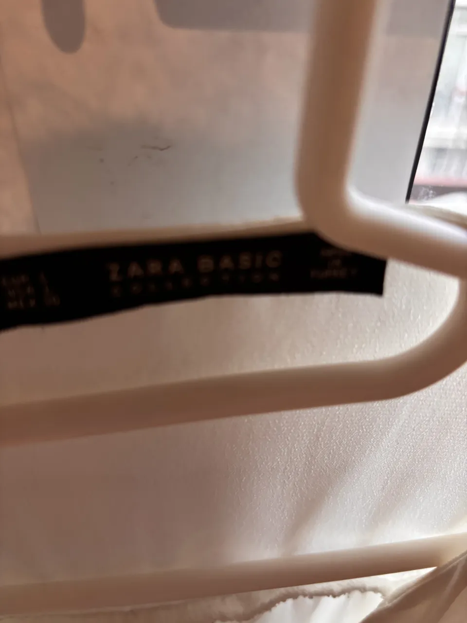 Blusa blanca de manga larga con botones en el escote.