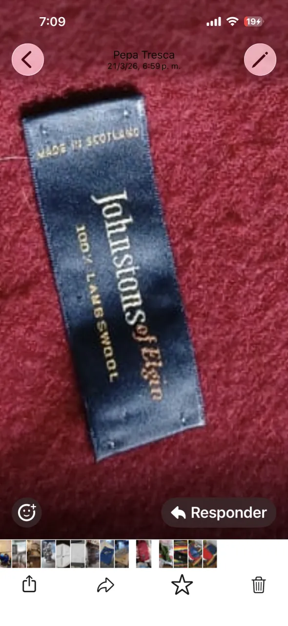 Bufanda de lana con flecos en los extremos. Etiqueta de la marca visible.