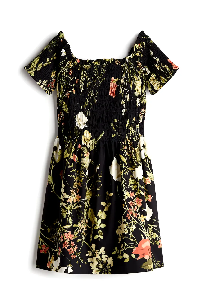 Vestido midi de mujer con estampado floral en tonos naranja, blanco y amarillo sobre fondo negro. Diseño con mangas cortas y detalle fruncido en el pecho. Ideal para un look fresco y femenino.