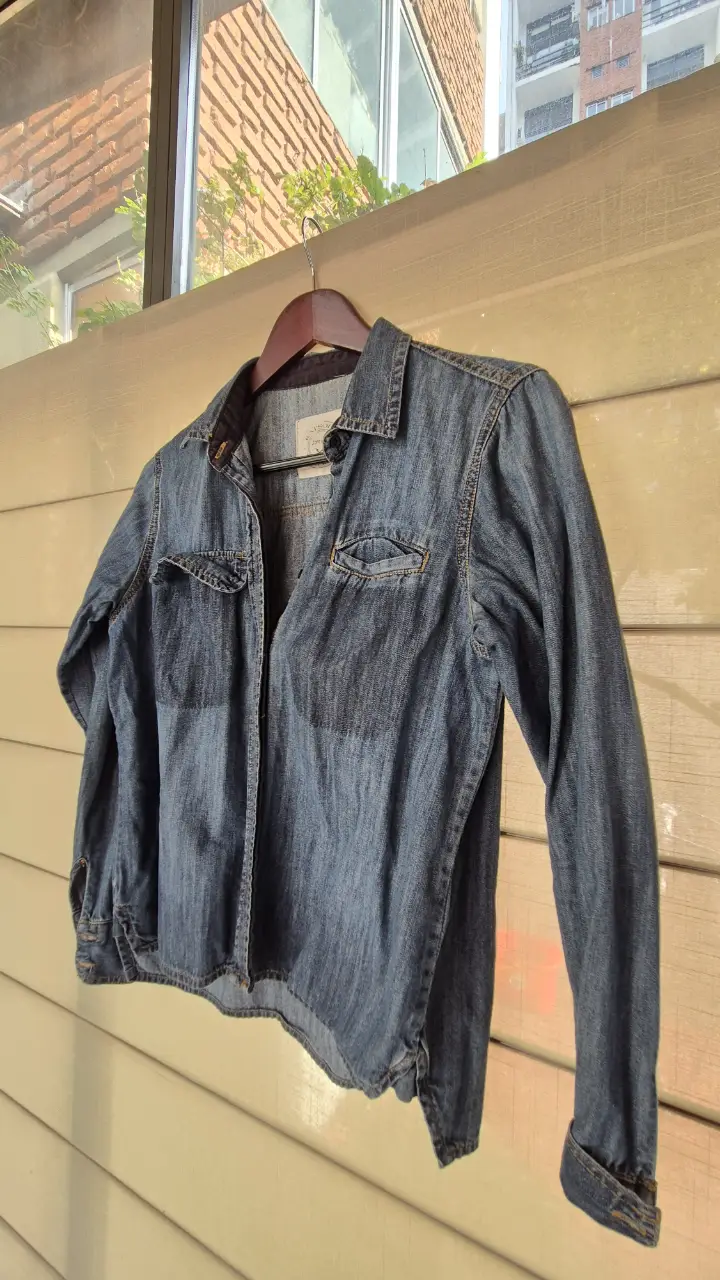 Camisa de jean azul, manga larga, con dos bolsillos delanteros. Marca Rapsodia, talle small.