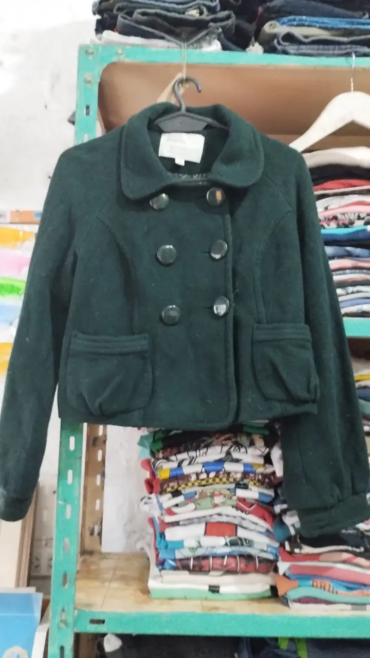 Campera corta de lana verde oscuro con botones y bolsillos delanteros. Ideal para un look casual y abrigado.