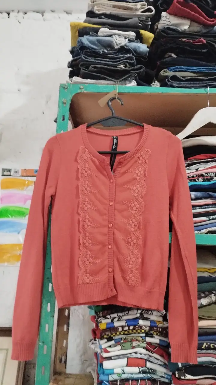 Cardigan de mujer color rosa coral con detalle de encaje en el frente. Ideal para un look casual y femenino.