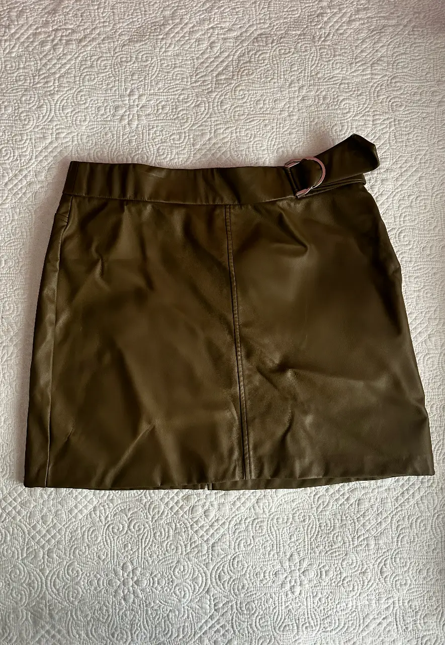 Pollera de cuero sintético color verde oscuro con cinturón y hebilla plateada. Talle XXL de la marca Zara. Ideal para un look elegante y moderno.