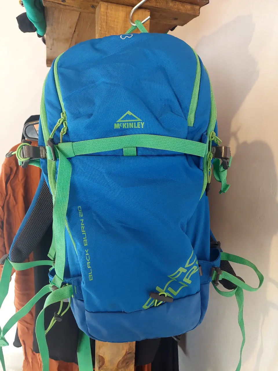 Mochila McKinley Black Burn 20, azul con detalles en verde. Ideal para actividades al aire libre y trekking. Cuenta con correas ajustables, múltiples compartimentos y capacidad de 20 litros.