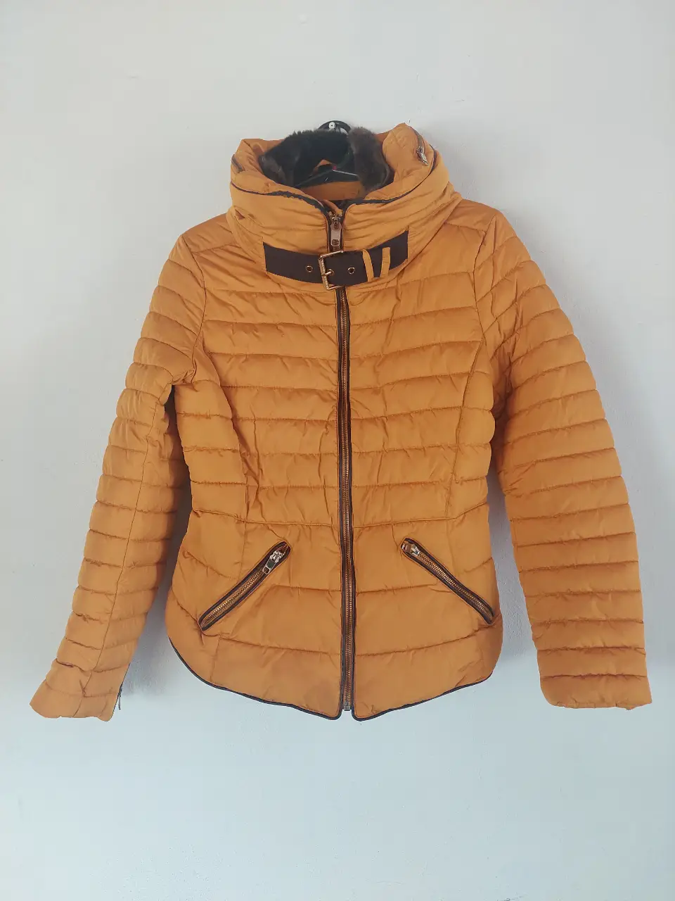Campera puffer amarilla de mujer, con cuello alto y detalle de piel sintética. Tiene cierre y bolsillos con cierre. Marca Zara Basic. Es color mostaza!