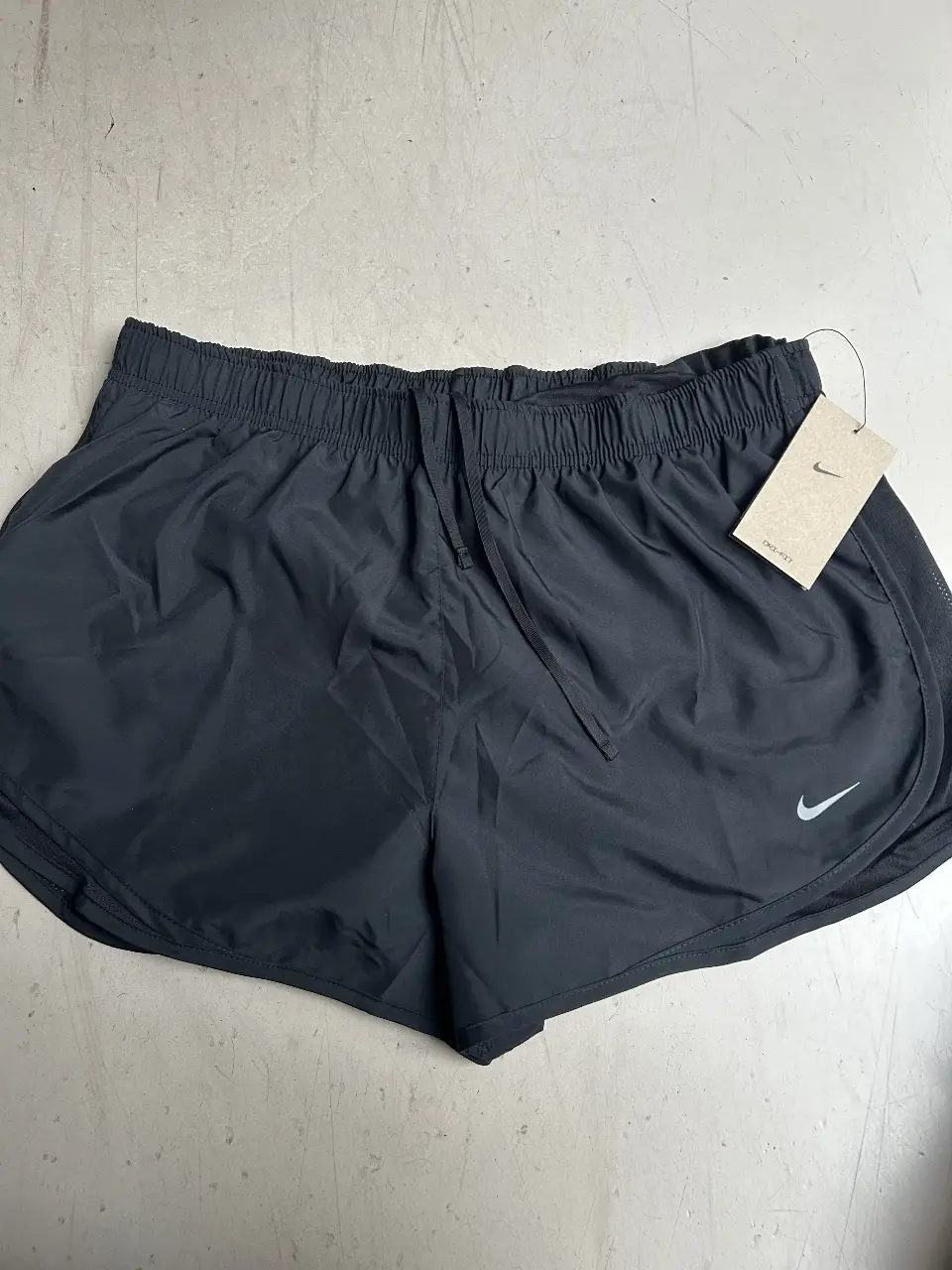 Short deportivo negro de mujer, ideal para running y entrenamiento. Confeccionado con materiales ligeros y transpirables, este short ofrece comodidad y libertad de movimiento. Cuenta con un diseño moderno y el icónico logo de la marca.