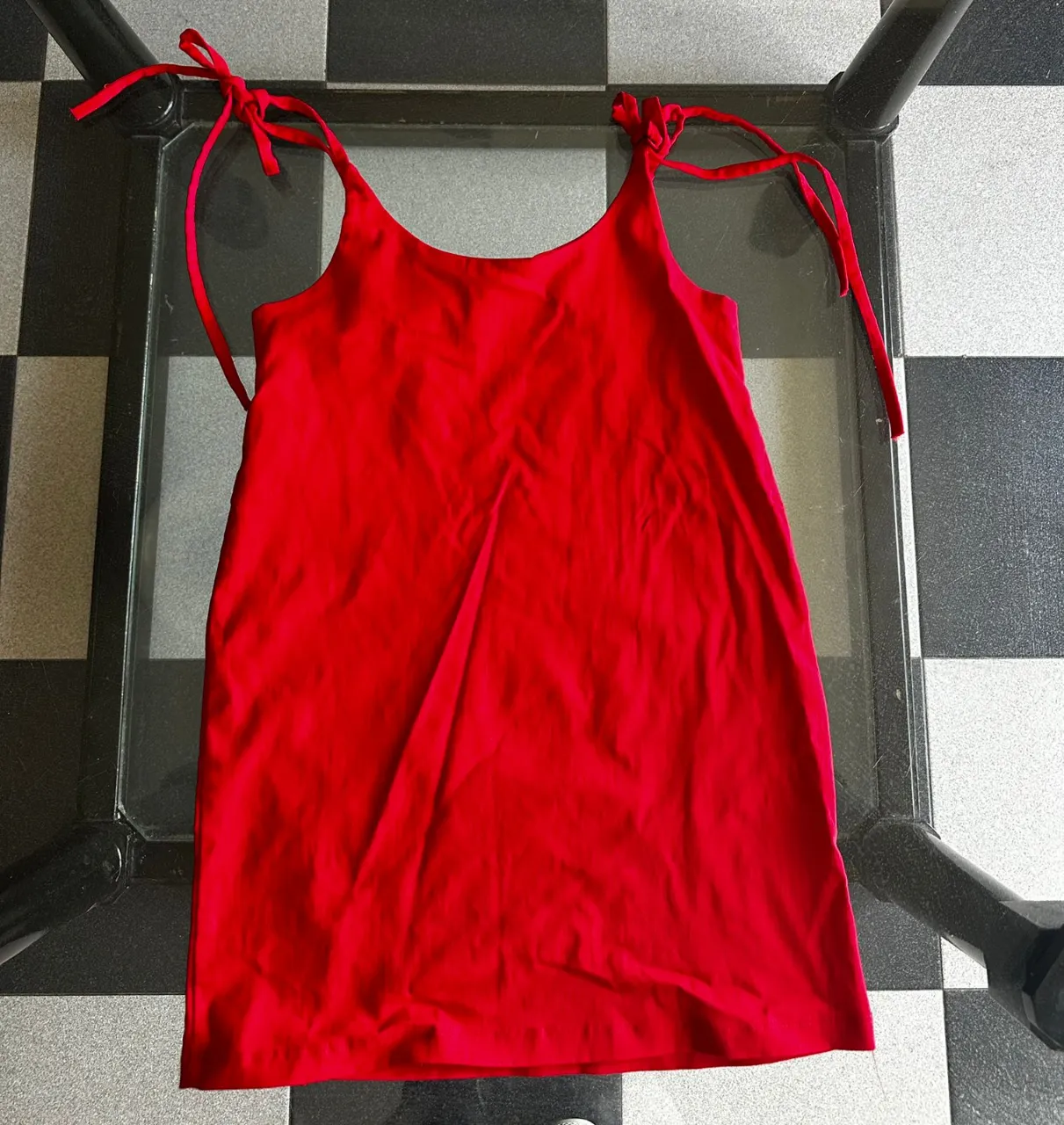 Vestido rojo vibrante con tiras finas regulables en los hombros. Ideal para un look fresco y canchero en días de calor.