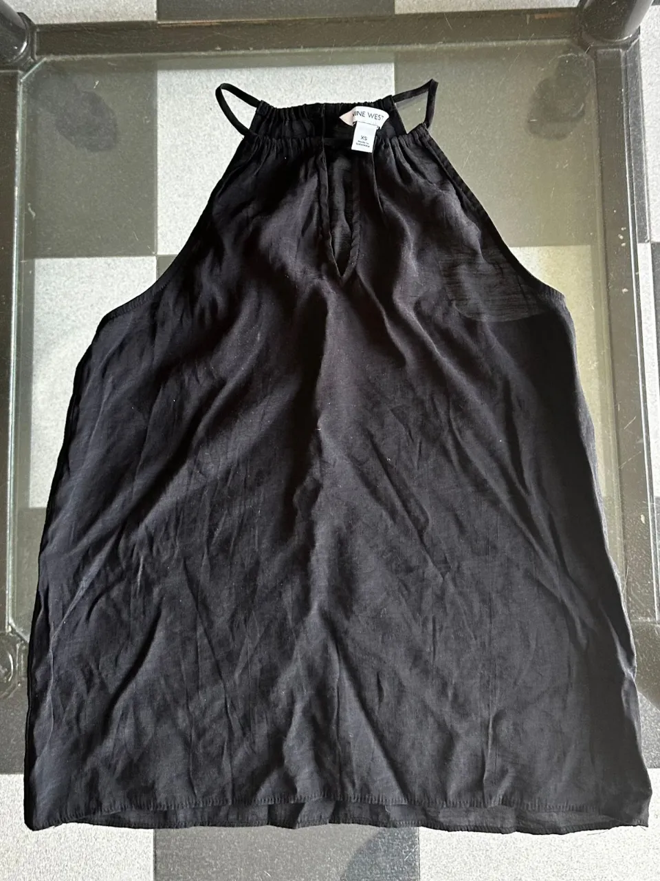 Musculosa negra con cuello halter y detalle de tajito en el escote. Ideal para un look canchero y fresco.