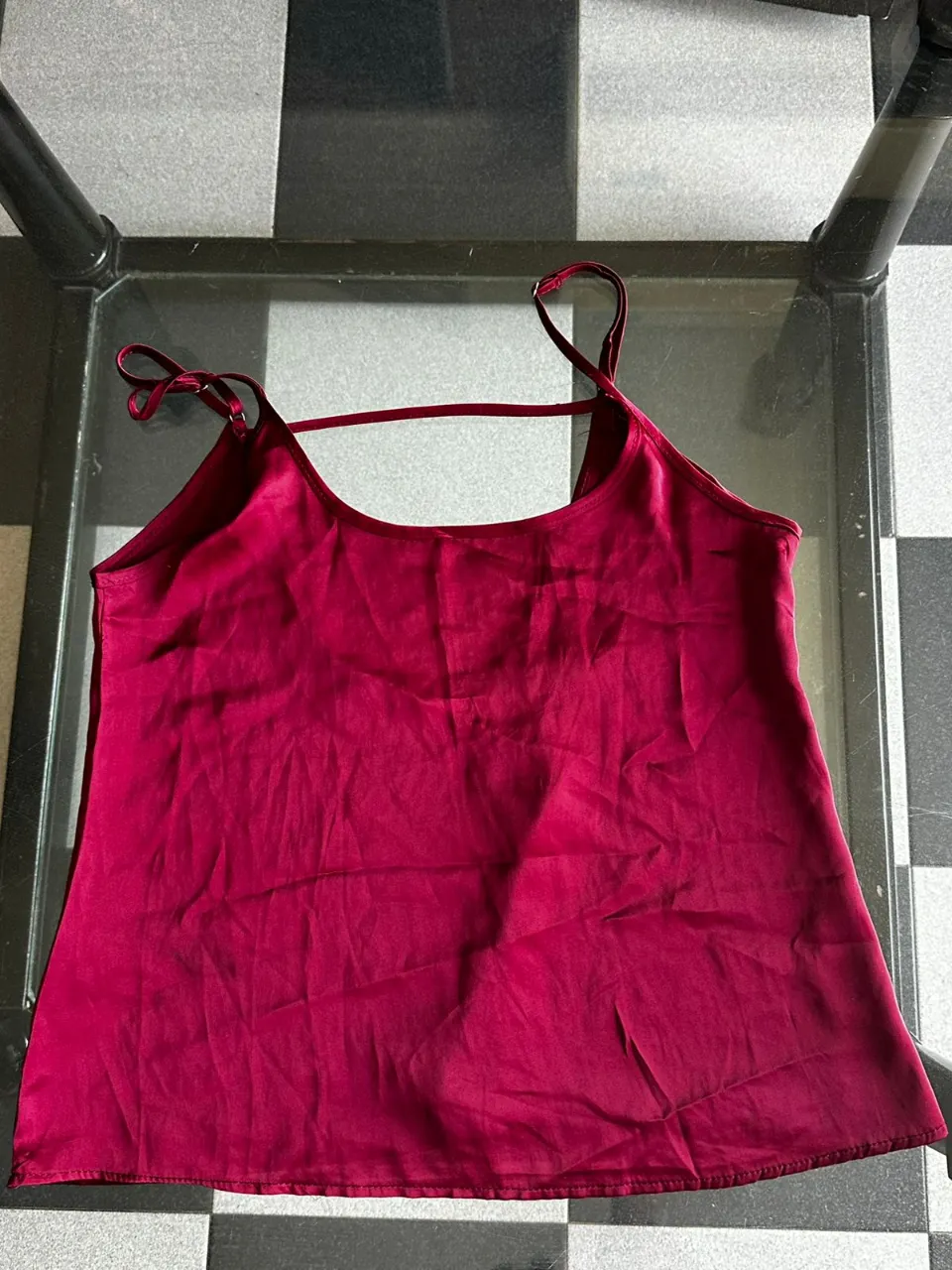 Top de seda color bordó, con tiras finas y escote delicado. Ideal para un look elegante o casual.