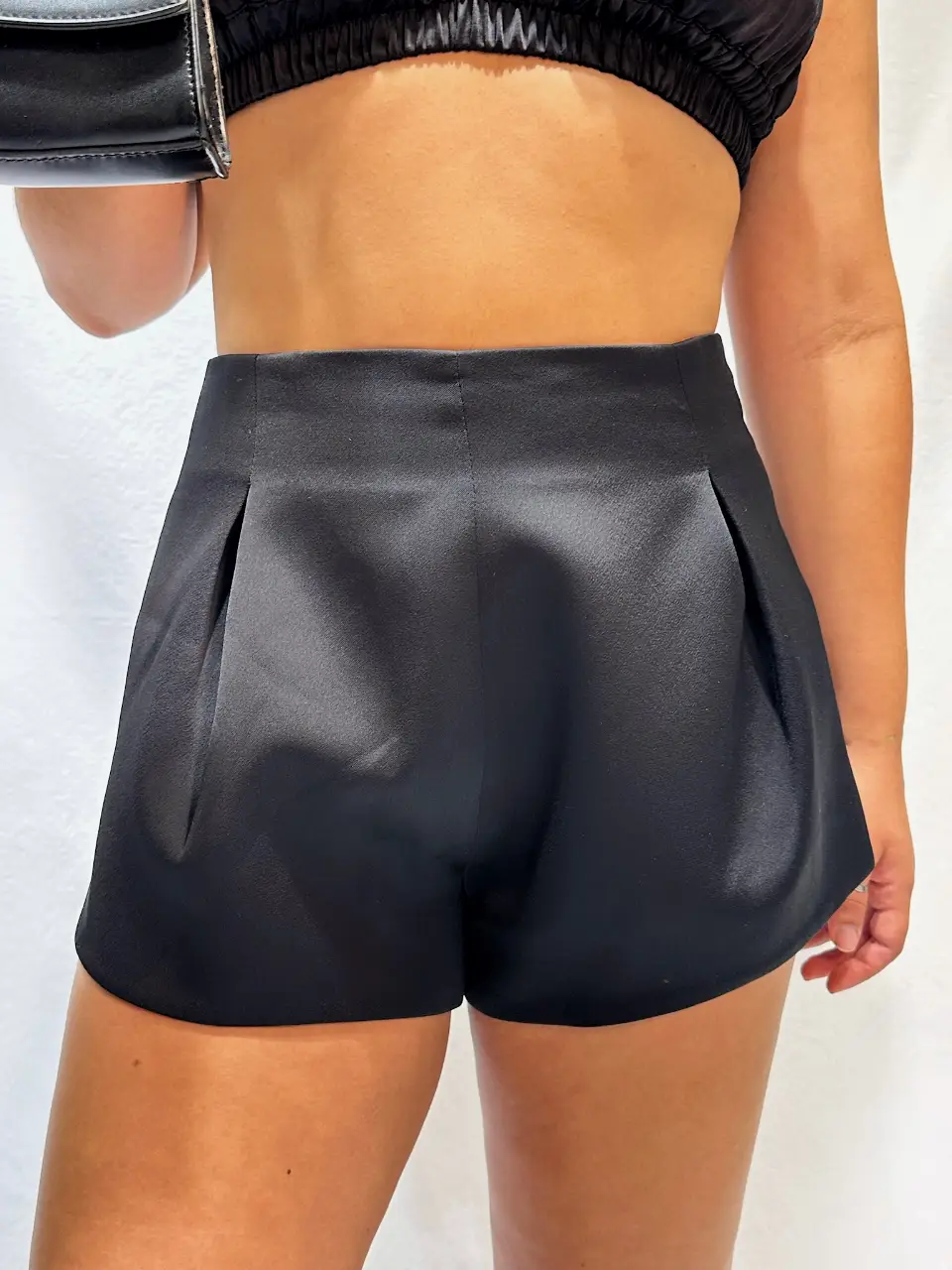 Shorts de vestir negros de tiro alto, confeccionados en tela satinada. Ideal para un look elegante y sofisticado.