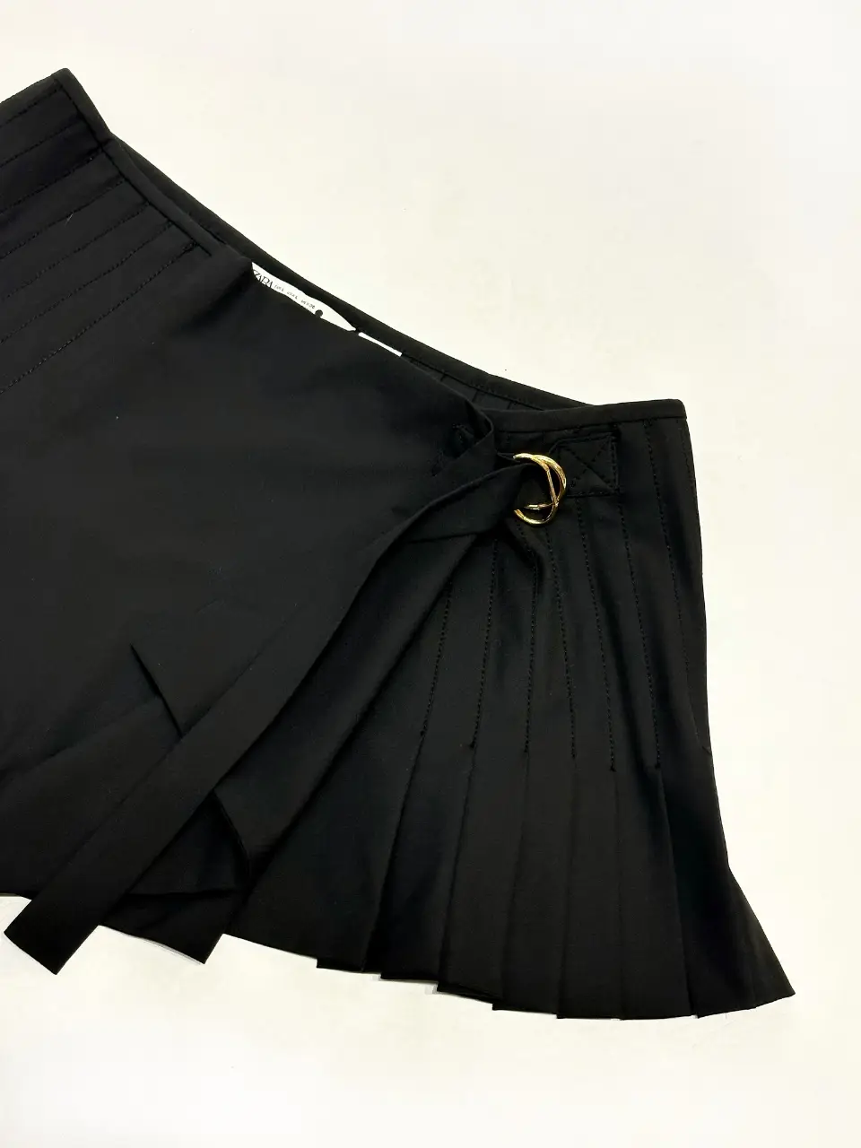 Pollera sastrera negra ZARA con detalles plisados y hebilla dorada. Ideal para un look elegante y moderno.
