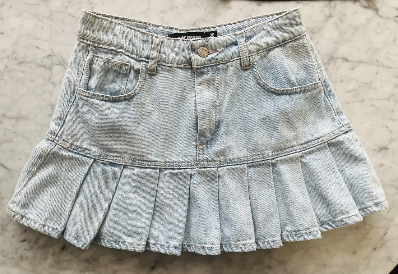 Pollera de jean tiro medio con tablas. Lavado celeste claro, ideal para looks casuales y frescos.