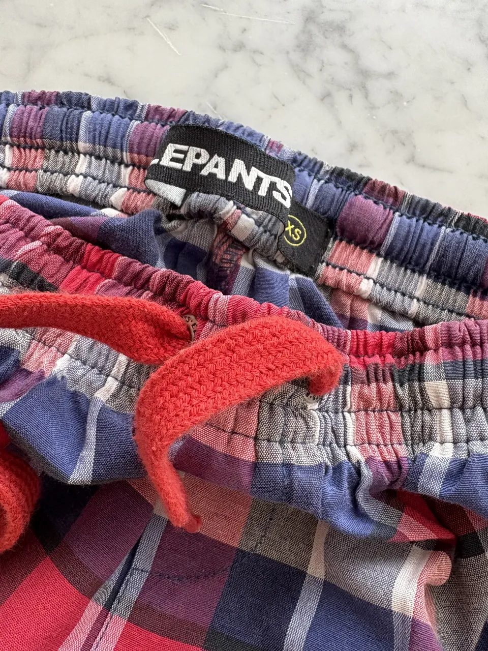 Pantalón de pijama a cuadros rojos, azules y blancos. Con cordón ajustable en la cintura y bolsillos laterales. Ideal para estar cómodo en casa. talle XS (chico, lo uso una nena de 11/12 años)